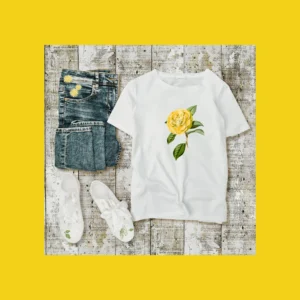yellow flower decal on t shirt with jeans and sneakers laying next to it