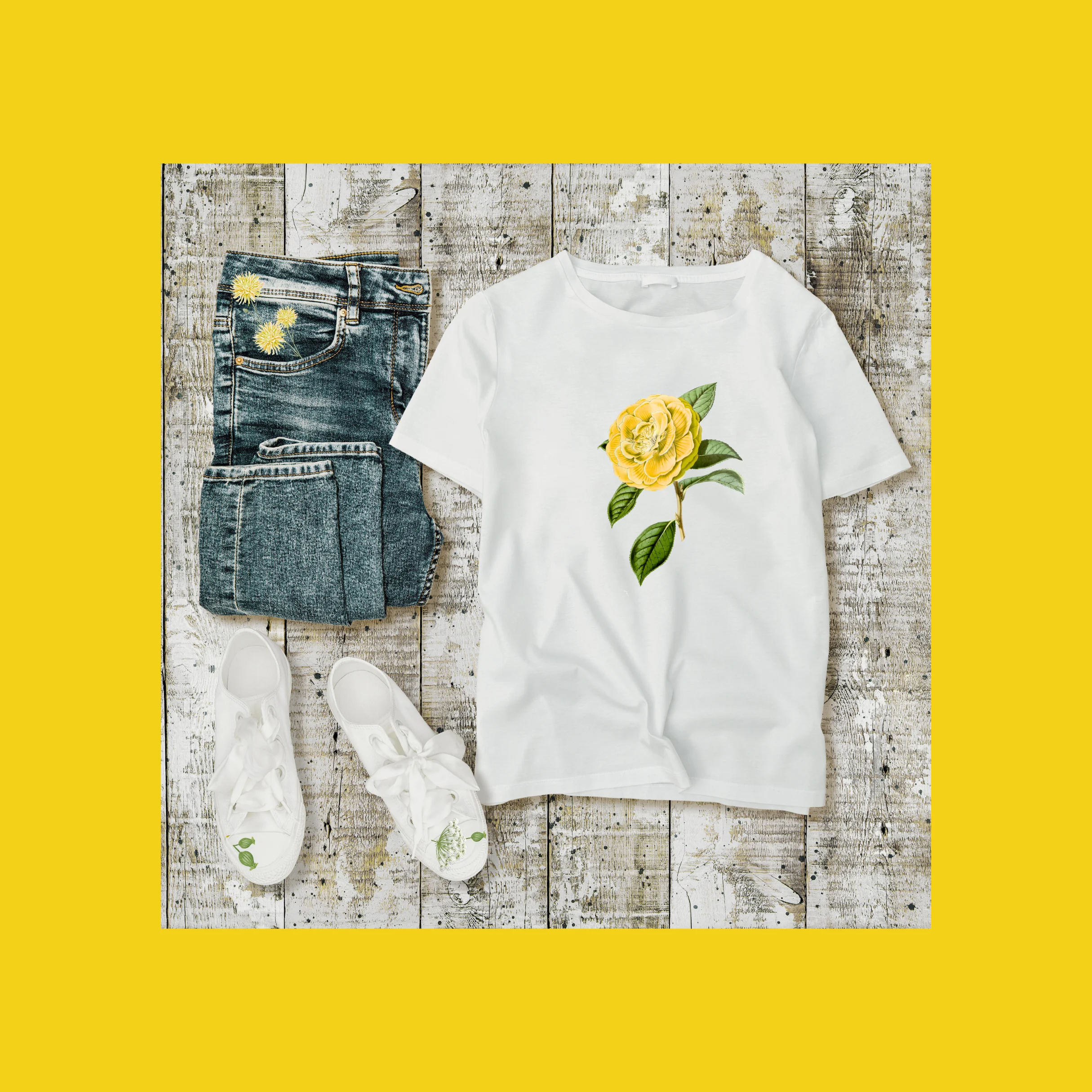 yellow flower decal on t shirt with jeans and sneakers laying next to it